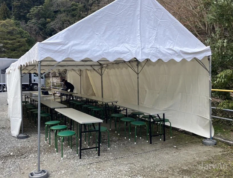 テントと机・椅子を配置した屋外食事スペース